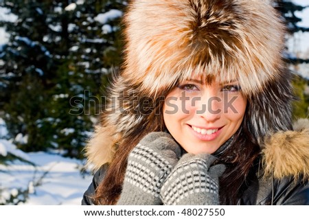 portrait of young smiling woman in fur cap