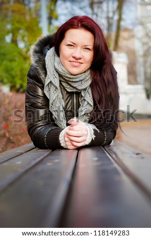 young girl lying down on a bench