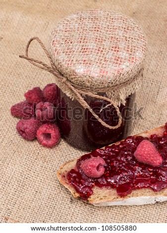 Jar with Raspberry Jam on rustic background