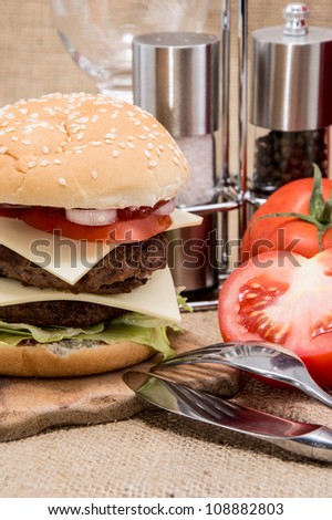 Double Burger with ingredients on rustic background