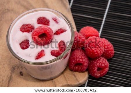 Raspberry Yogurt with fresh fruits on black background