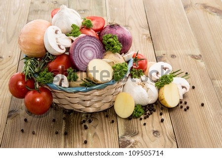 Different Vegetables in a basket on wooden background