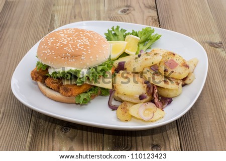 Fish Burger with fried Potatoes on wooden background