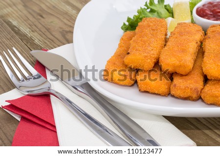 Portion of Fish Fingers and Chips on wooden background