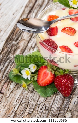 Vanilla Pudding with Strawberries on wooden background