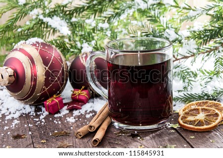 Glass with mulled wine on a snow covered background