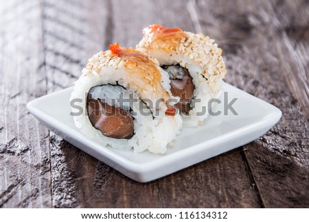 Small plate with Sushi Rolls on wooden background