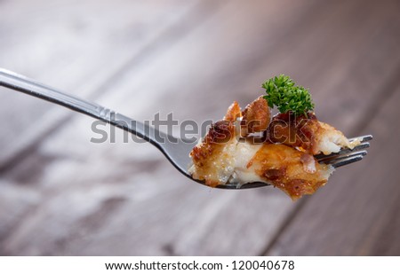 Fork with Chicken Meat on wooden background
