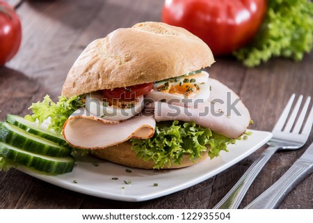 Small plate with Chicken Sandwich on wooden background