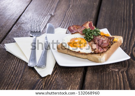 Fried Egg Sandwich on a plate (wooden background)