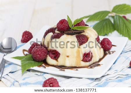 Homemade Raspberry Vanilla Pudding with fresh fruits and chocolate sauce