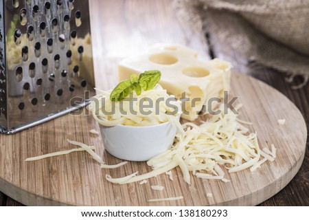 Emmentaler with Cheese Grater on wooden background