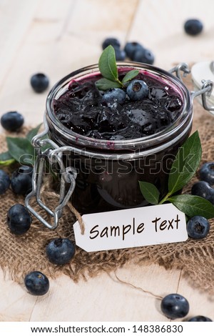 Portion of fresh made Blueberry Jam with fruits and a small label