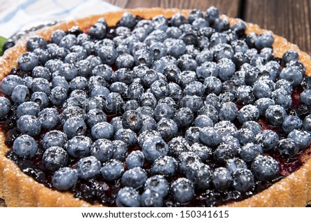 Blueberry Tart with fresh fruits on vintage wooden background