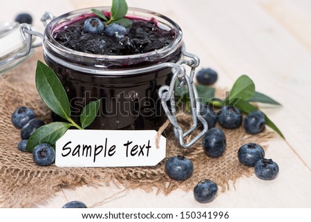 Portion of fresh made Blueberry Jam with fruits and a small label