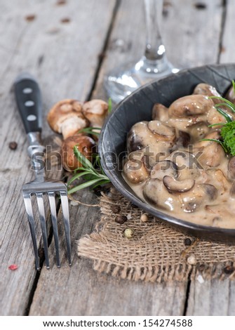 Fried Mushrooms with Cream Sauce and herbs in a vintage Pan