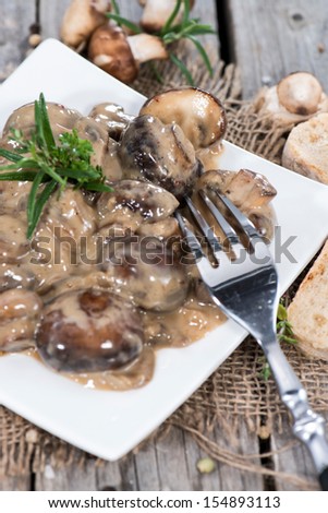 Portion of Creamy Mushrooms on vintage wooden background