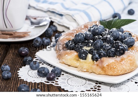 Small Blueberry Tart on vintage wooden background with fresh fruits