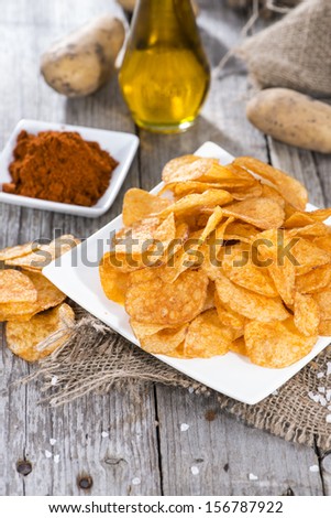 Heap of Paprika Potato Chips on rustic background