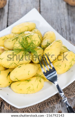 Fresh Potatoes with Herbs on vintage wooden background