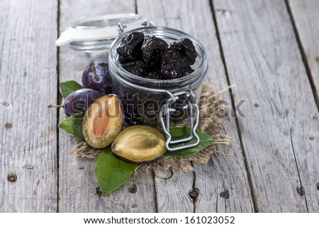 Portion of dried Plums on vintage woosen background