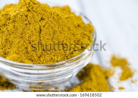 Curry Powder (in a bowl) on white vintage wooden background