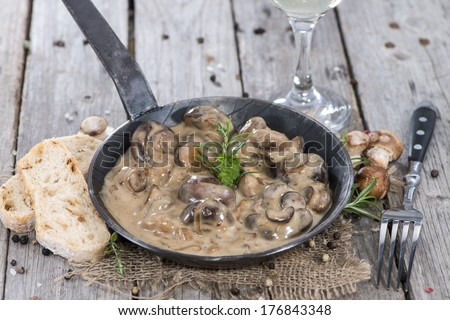 Pan with Mushrooms in a Cream Sauce on vintage background