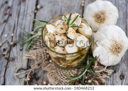 Preserved Garlic with fresh herbs on vintage background