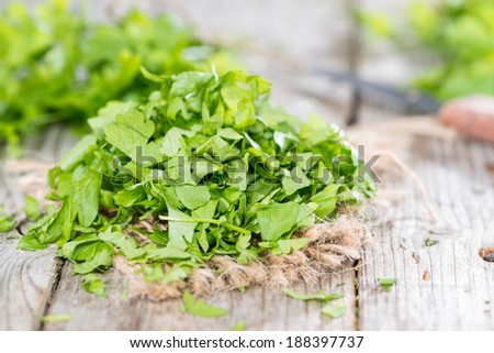 Heap of fresh cutted flat leaf Parsley (on wooden background)