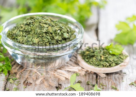 Portion of dried flat leaf Parsley on wooden background