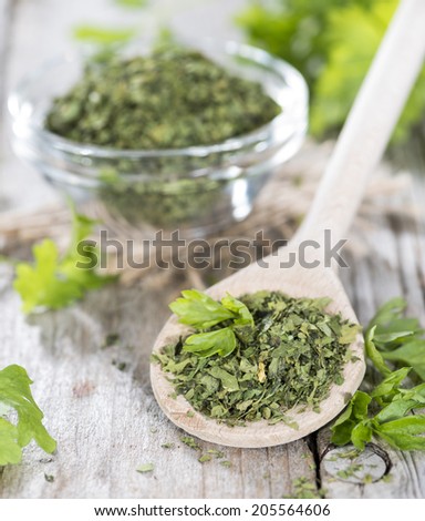 Small portion of dried Parsley on weathered wooden background
