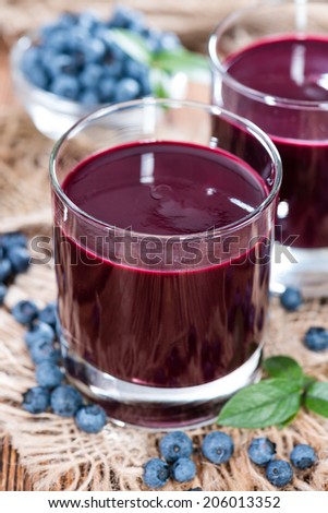 Glass with Blueberry Juice and fresh fruits (close-up shot)