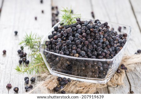 Dried Juniper Berries on wooden background (close-up shot)