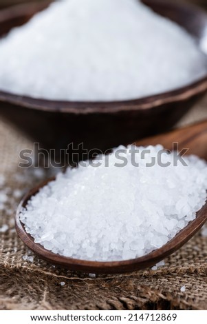 Heap of Salt (close-up shot) on dark wooden table
