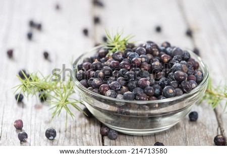 Dried Juniper Berries on wooden background (close-up shot)