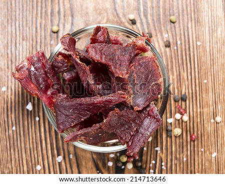 Spicy Beef Jerky on vintage wooden background (close-up shot)
