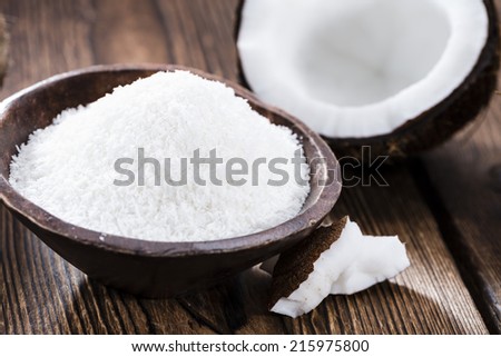 Portion of Grated Coconut on wooden background (close-up shot)