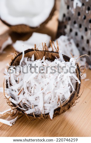 Heap of Grated Coconut (close-up shot) on wooden background