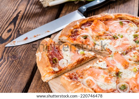Salmon Pizza (with garlic and cheese) on rustic wooden background