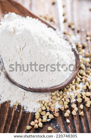 Buckwheat Flour with some grains on dark wooden background