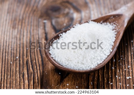 Grated Coconut (detailed close-up shot) on wooden background