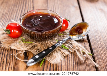 Barbeque Sauce with Tomatoes, Smoked Salt and fresh Herbs (on rustic wooden background)