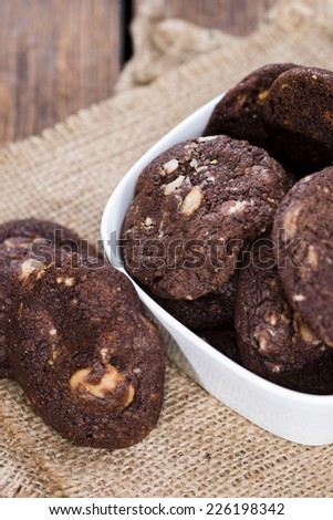 Homemade chocolate Cookies (with macadamia nuts) on wooden background