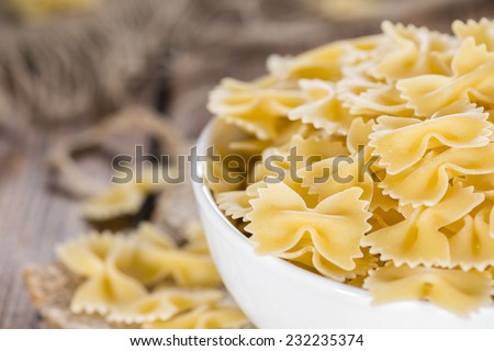 Farfalle (commonly known as Bow-Tie Pasta) in a bowl on wooden background
