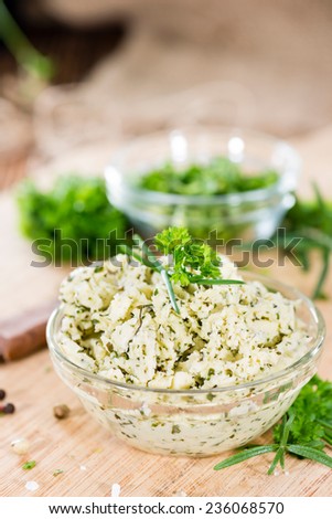 Herb Butter in a small bowl (on wooden background)