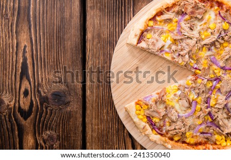 Homemade Tuna Pizza (with corn and red onions) on wooden background