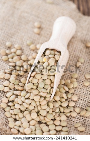 Heap of brown Lentils on wooden rustic background