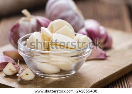 Peeled Garlic (close-up shot) on vintage wooden background
