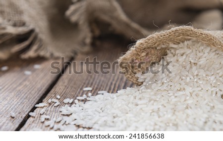 Heap of uncooked Rice (close-up shot) on wooden background