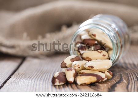 Heap of Brazil Nuts (close-up shot) on wooden background